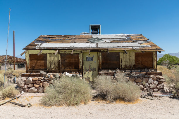 废弃的房子和野营拖车停在沙漠中间图片下载