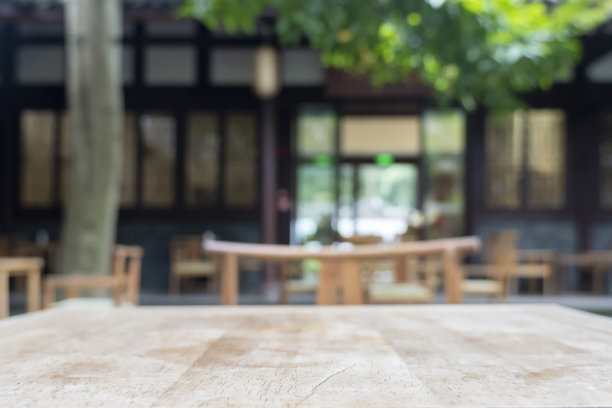 露天中国传统茶馆的木制桌椅，外面有很多树图片下载