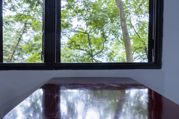 在中国传统茶馆的窗户旁边有木桌，外面有很多树图片下载