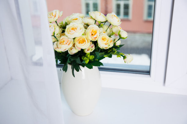 一束美丽的玫瑰花插在窗户上的陶瓷花瓶里图片下载