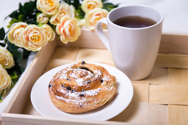 早餐，小面包和茶放在木托盘上图片下载