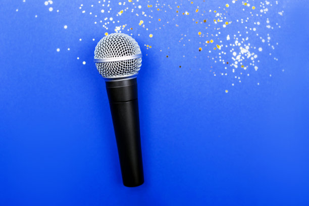 蓝色背景上装饰着五彩纸屑的麦克风。最小的原料油。图片下载
