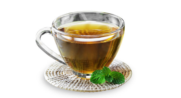 有机红茶在玻璃杯上木制杯垫在白色孤立的背景与剪切路径。热的中国红茶配薄荷叶味道很好。饮酒和饮料概念。图片下载