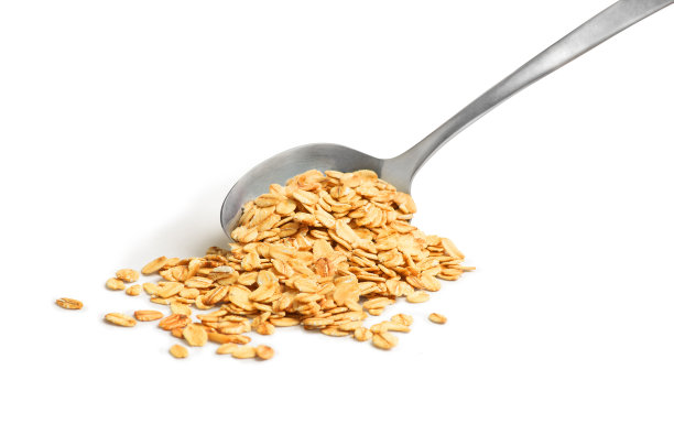 白色背景下勺子里的燕麦片图片下载
