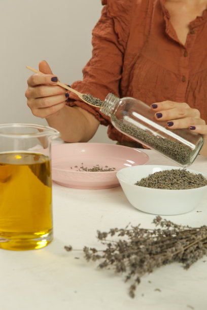 用薰衣草做草药油的女人。天然有机自制化妆品的浸渍工艺。联赛的照片。图片下载