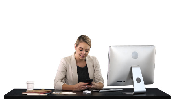 漂亮的女商人坐在办公桌前用手机发短信图片下载