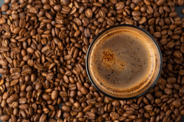 顶视图的热咖啡杯和模糊的咖啡豆。图片下载