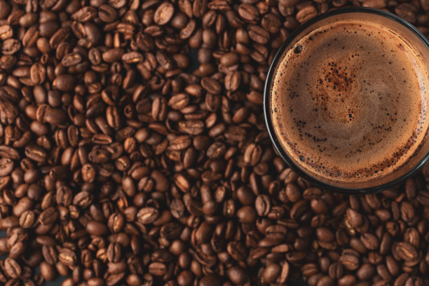 热咖啡杯和模糊咖啡豆的俯视图。图片下载