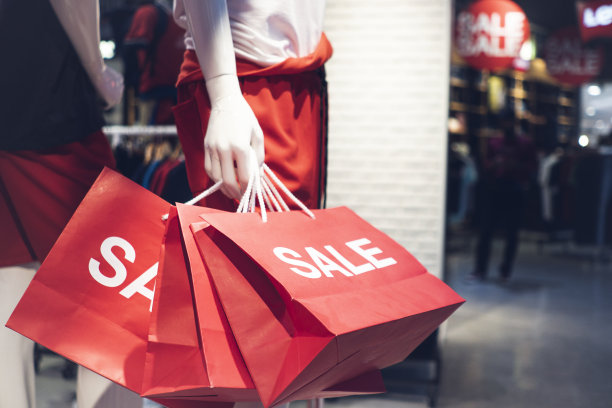 购物中心百货商店里拿着促销购物袋的时装模特图片下载