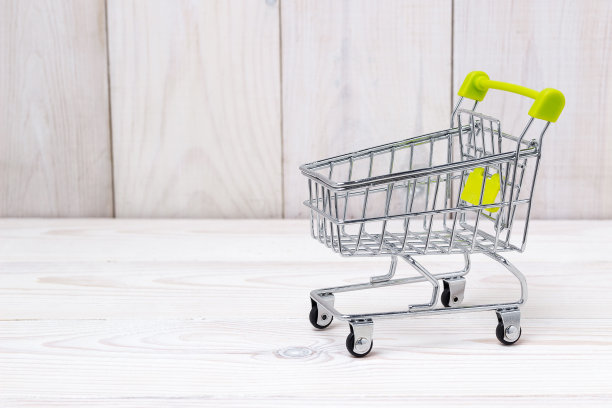 空购物车在白色木制背景。侧视图图片下载