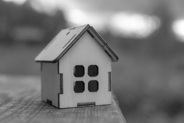 一个木制的小玩具屋立在木桌的边上，可能会倒。单色。本空间图片下载