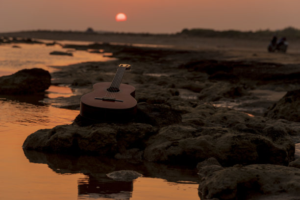 那把吉他在日落时放在地上图片下载