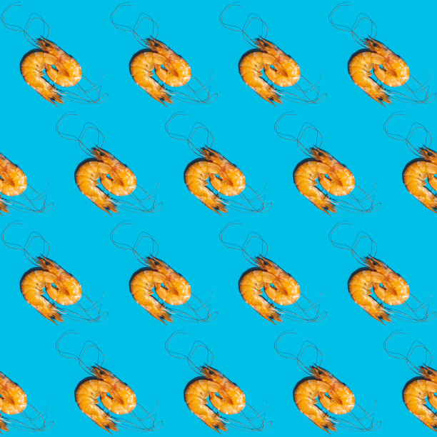 食物对角线无缝模式的虾在蓝色的背景。创造性的极简主义平躺与硬光图片下载