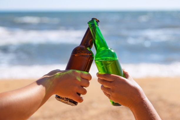 双手拿着啤酒瓶在烤面包图片下载