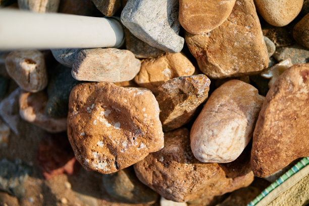 希腊的大棕色岩石撑着沙滩伞的特写图片下载