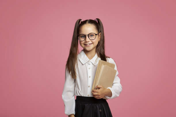 学校和教育。穿着校服，戴着眼镜拿着书的微笑学生图片下载
