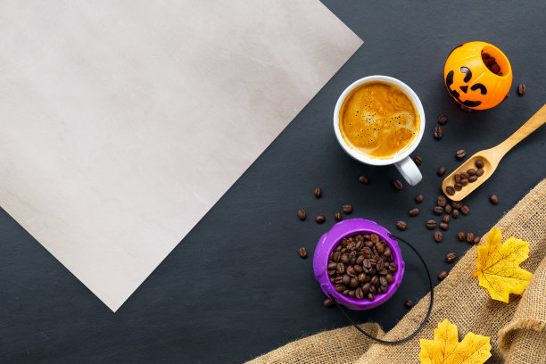万圣节装饰用热咖啡和豆子在黑暗的背景。平的。为文本复制空间。图片下载
