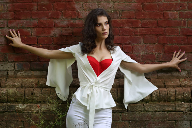 穿白色西装的女孩靠在砖墙上图片下载