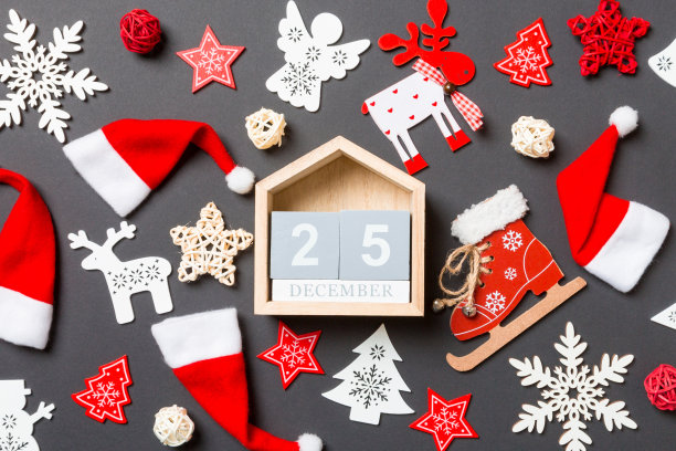 木制日历的顶视图。12月25日。黑色背景的新年装饰品。圣诞快乐概念图片下载
