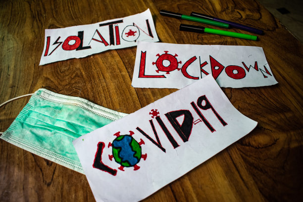 在木桌上用记号笔和口罩手绘Covid - 19、封锁和隔离。图片下载