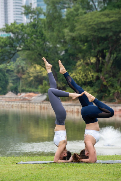 两个年轻的健身亚洲妇女一起练习Acroyoga放松在城市公园图片下载