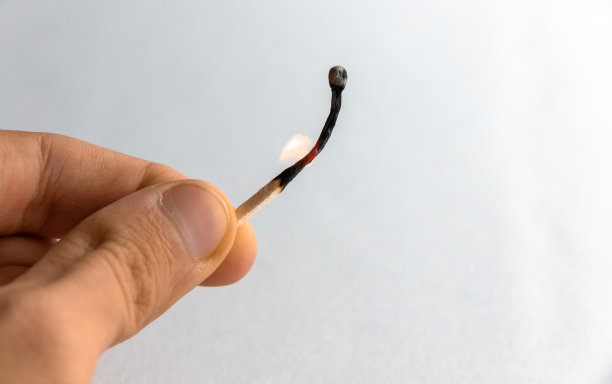 在纯白色的背景上，一个少年手里拿着一根烧了一半的火柴图片下载