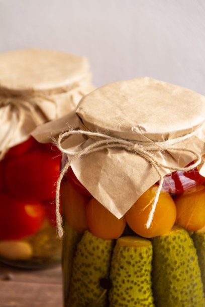 玻璃罐里的腌黄瓜和西红柿，背景很亮图片下载