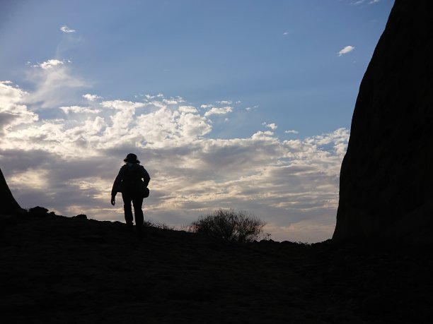 一个男性游客的剪影徒步上山在一个沙漠的夜晚图片下载