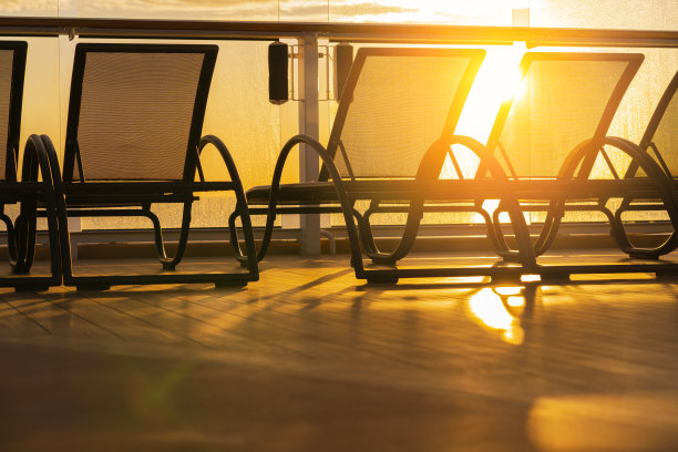 一排空的日光浴长椅上的游轮木制甲板日落时刻图片下载