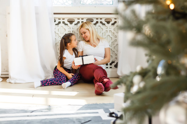母亲和女儿与礼物盒的照片，圣诞节图片下载