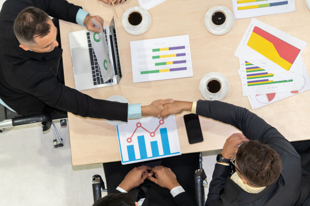 团队商务人员在会议桌上握手图片下载