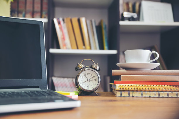 笔记本电脑和书本在学校桌子上，学生学习和考试在图书馆。木制书桌与台式笔记本笔记本和日记，网上工作在家办公。书桌为学生概念。图片下载