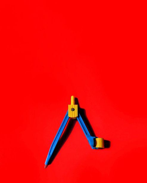 用铅笔在红色背景上画圆圈的塑料指南针。创造性的概念图片下载