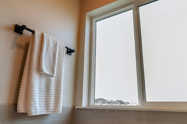 浴室内部，白色毛巾挂在墙上的黑色杆子上图片下载