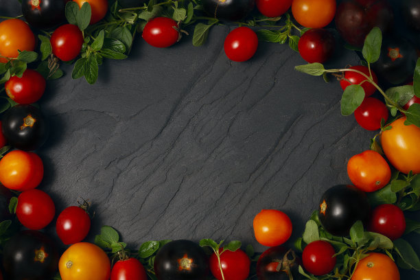 框架由蔬菜，黄色，红色和黑色的圣女果，在黑色的背景图片下载