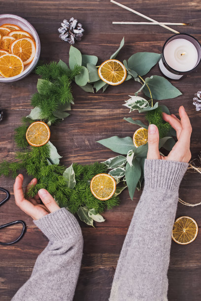 女人的手在针织毛衣牵手制作圣诞花环图片下载
