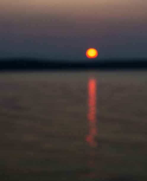 湖面上落日的散焦抽象图像。散景效果图片下载