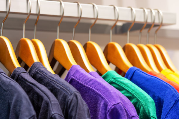 五颜六色的t恤挂在店里的木衣架上，侧视图图片下载