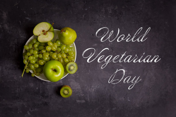 世界素食者日以粉笔为背景，绿色水果、苹果、葡萄、猕猴桃、梨为背景图片下载