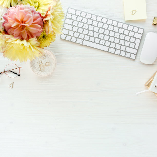 平放的女性办公桌。女性的工作空间有电脑，粉红色和黄色的玫瑰花，配件，日记，眼镜在白色的背景。俯视图图片下载