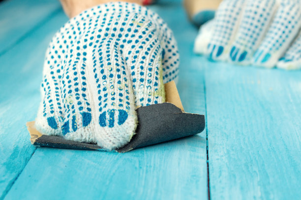 打磨用砂纸、海绵、木漆、蓝色木桌背景近处打磨图片下载