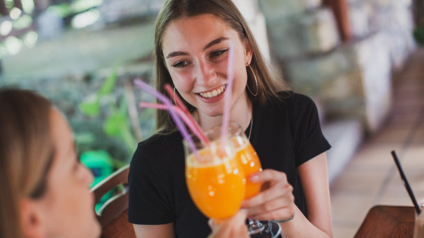 美丽的女人享受在咖啡和果汁在咖啡店图片下载