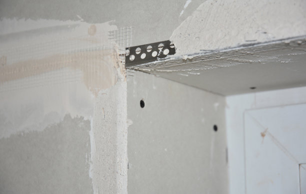 这是一个特写镜头，特写的是围绕窗户角落的一面墙，上面有固定的角珠和一层饰面，灰泥。图片下载