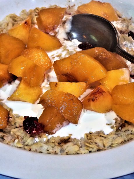 版权免费照片-添加甜美的乔治亚桃子到我的早上的燕麦-孤立的近距离美味的燕麦顶部完美的桃子和蔓越莓-网站，食物博客和广告的最佳早餐照片-梦幻般的食物背景图片下载