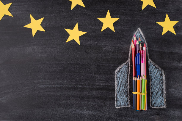 梦想成真的概念。上面俯瞰的照片绘制的飞船孤立在黑板背景与黄色星星贴纸图片下载