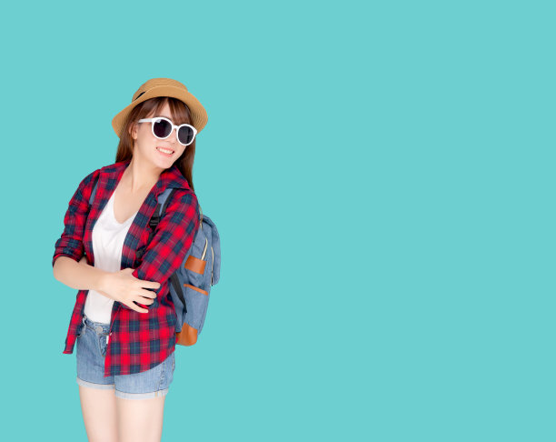 美丽的肖像年轻的亚洲女人戴太阳镜和帽子微笑兴奋和自信享受暑假孤立的蓝色背景，模特女孩开朗有背包度假，旅游概念。图片下载