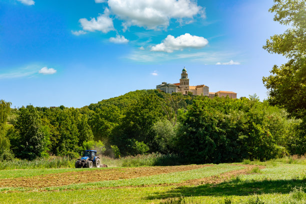 帕农哈尔马修道院的山上有农地和拖拉机在夏天图片下载
