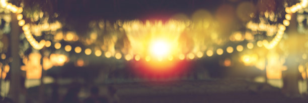 模糊的散景光在日落与黄色的串灯装饰在海滩餐厅图片下载
