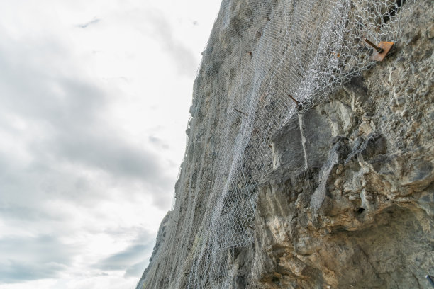 金属网的保护，以防止落下的石头对天空和云。Vardzia,格鲁吉亚图片下载