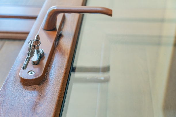 一个内部门把手和钥匙锁的特写图像。入口或阳台门，室外拍照图片下载